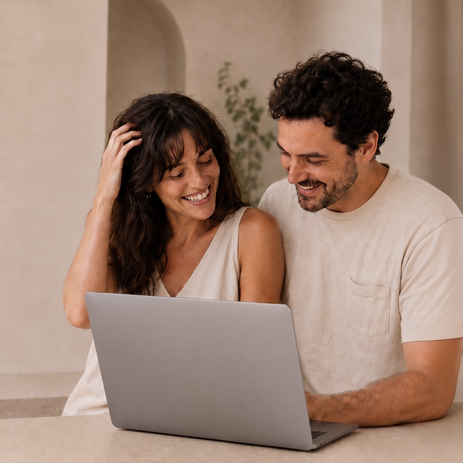 Happy couple smiling together while browsing on a laptop